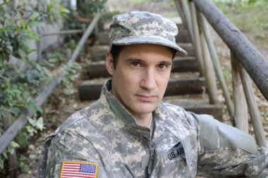 Dışarıdaki üniformalı yakışıklı genç askerin portresi.