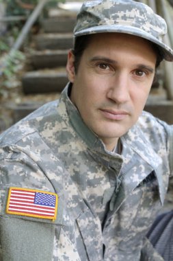 Dışarıdaki üniformalı yakışıklı genç askerin portresi.