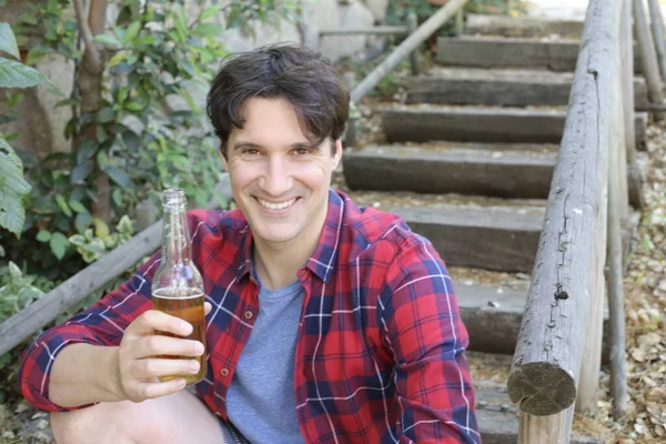 Elinde bira şişesi olan yakışıklı bir gencin portresi.