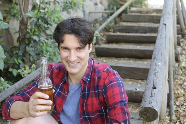 Elinde bira şişesi olan yakışıklı bir gencin portresi.