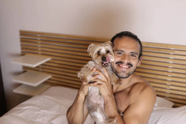 在床上抱着可爱的小狗的年轻帅小伙裸男的特写 — 图库照片