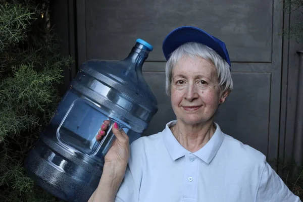 水配達のサービスの成熟した女性のクローズアップ肖像と大きな水のボトル — ストック写真
