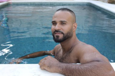 Yüzme havuzunda rahatlayan yakışıklı genç adamın yakın plan portresi.