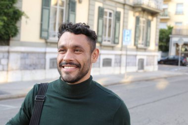 close-up portrait of handsome young man in turtleneck sweater on city street