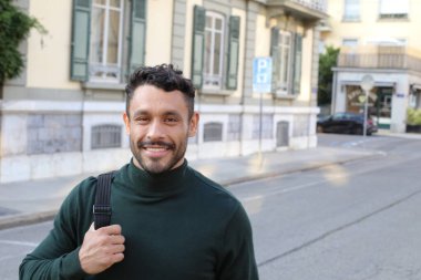 close-up portrait of handsome young man in turtleneck sweater on city street