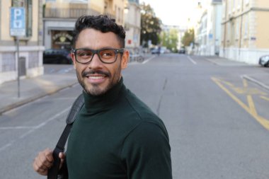 close-up portrait of handsome young man in turtleneck sweater on city street