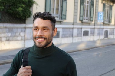close-up portrait of handsome young man in turtleneck sweater on city street