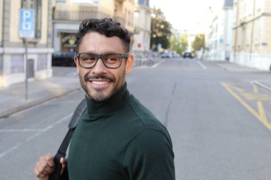close-up portrait of handsome young man in turtleneck sweater on city street