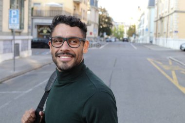 close-up portrait of handsome young man in turtleneck sweater on city street