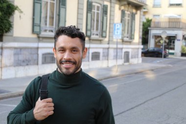 close-up portrait of handsome young man in turtleneck sweater on city street