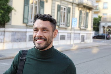 close-up portrait of handsome young man in turtleneck sweater on city street