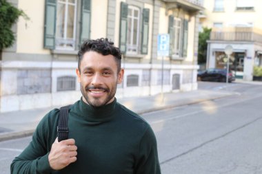 close-up portrait of handsome young man in turtleneck sweater on city street