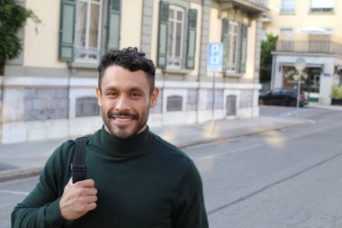close-up portrait of handsome young man in turtleneck sweater on city street