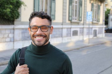 close-up portrait of handsome young man in turtleneck sweater on city street