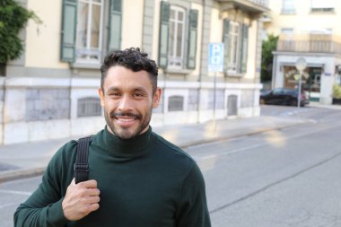 close-up portrait of handsome young man in turtleneck sweater on city street