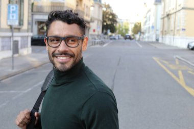 close-up portrait of handsome young man in turtleneck sweater on city street