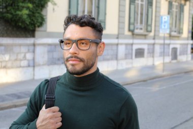 close-up portrait of handsome young man in turtleneck sweater on city street