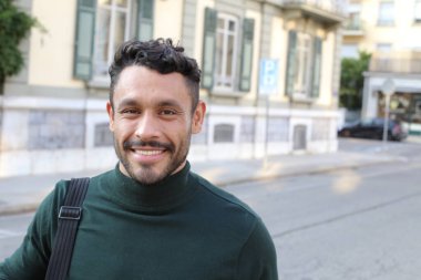 close-up portrait of handsome young man in turtleneck sweater on city street