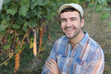 close-up portrait of handsome young man standing in grapes garden