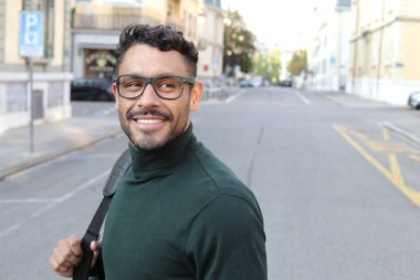 close-up portrait of handsome young man in turtleneck sweater on city street