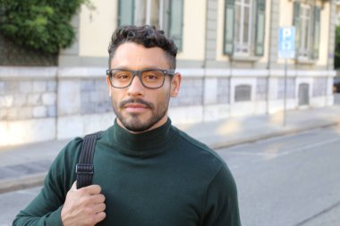close-up portrait of handsome young man in turtleneck sweater on city street
