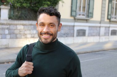 close-up portrait of handsome young man in turtleneck sweater on city street