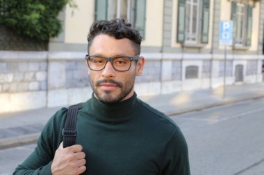 close-up portrait of handsome young man in turtleneck sweater on city street