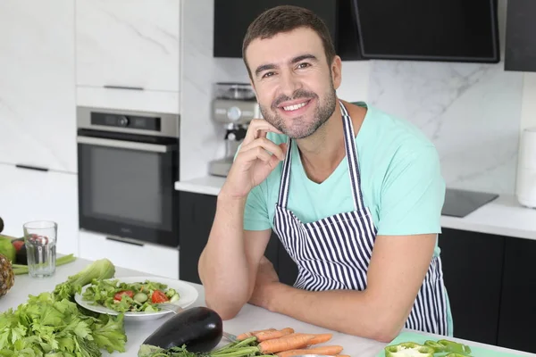 自宅のキッチンに野菜が立ち並ぶハンサムな青年の肖像画 — ストック写真