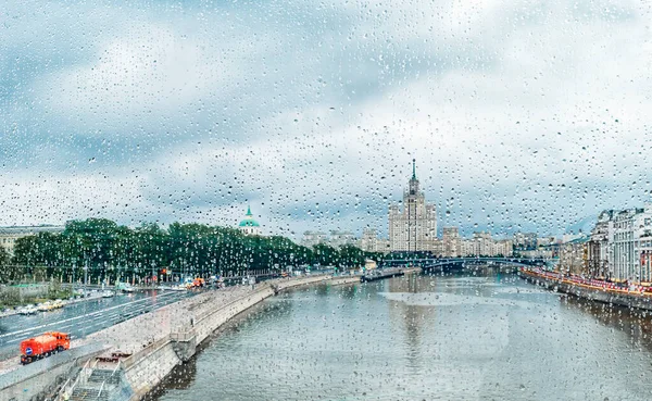 モスクワ、ロシアのKotelniceskaya堤防の建物のモスクワ川の雨滴とガラスを通して見る — ストック写真