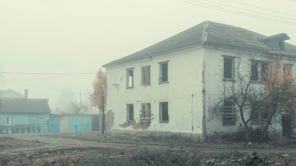 雾蒙蒙的一天，路边一幢废弃的两层木房子 — 图库照片