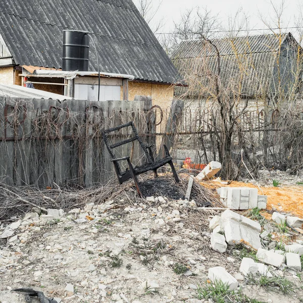 Yanmış sandalye, taht gibi, inşaat enkazı üzerinde duruyor. — Stok fotoğraf