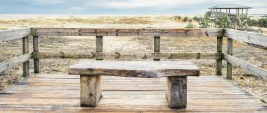 Curonian Gölü ve Curonian Körfezi 'nin kum tepelerine bakan ahşap bir bank.