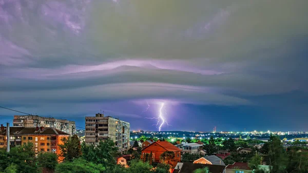 Tormenta sobre la ciudad por la noche, relámpagos brillantes entre densas nubes — Foto de Stock