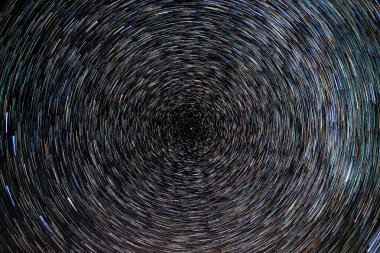 Yıldızsal izler, parlak yıldızların gece mavi gökyüzüne karşı Kutup Yıldızı etrafında dönüşleri.