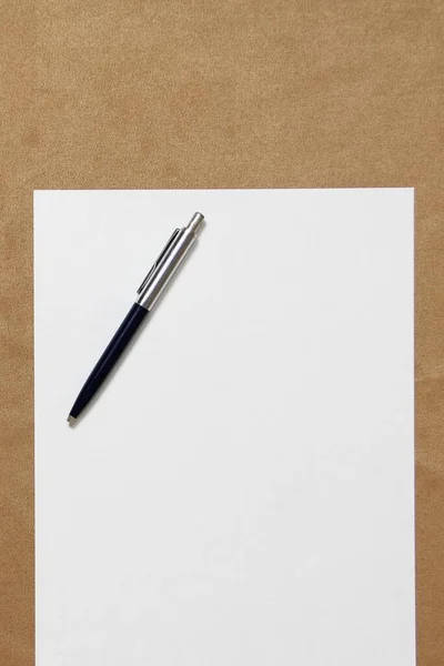 Sjabloon van wit papier met pen ligt op lichtbruine doek ondergrond. Concept van business plan en strategie. Stockfoto met lege ruimte voor tekst en ontwerp — Stockfoto