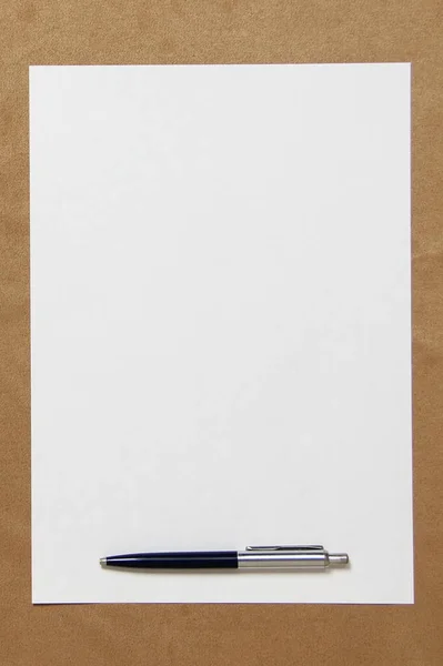 Mall av vitt papper med penna ligger på ljusbrun duk bakgrund. Begreppet affärsplan och strategi. Lagerfoto med tomt utrymme för text och design — Stockfoto