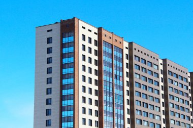 Modern şehir mimarisi, gökyüzünü yansıtan sıra sıra pencereler.