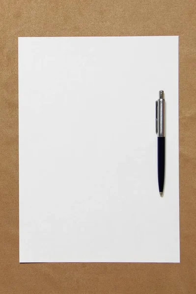 Modello di carta bianca con penna si trova su sfondo panno marrone chiaro. Concetto di business plan e strategia. Foto di scorta con spazio vuoto per testo e design — Foto Stock