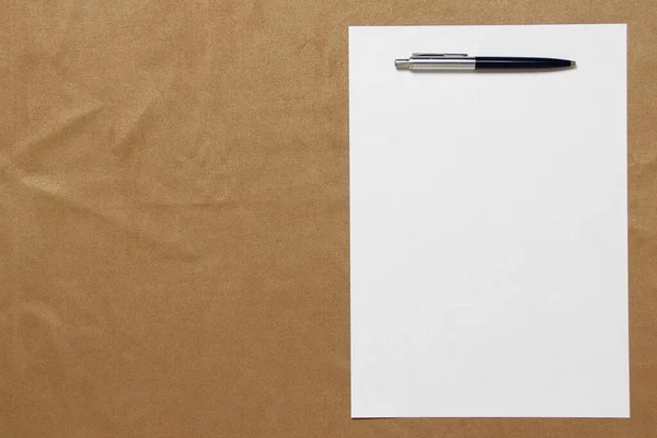 ペンのある白い紙のテンプレートは、薄い茶色の布の背景にあります。事業計画と戦略の概念。テキストとデザインのための空のスペースとストックフォト — ストック写真