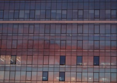 Modern bir ofis binasında bulutların yansıması. Cam cephe yapısının inşaatı