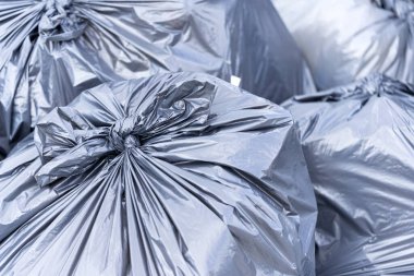 Çöp sahasında büyük siyah torbalarda bir çöp yığını. İşlem için atık hazırlandı