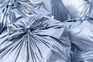 Çöp sahasında büyük siyah torbalarda bir çöp yığını. İşlem için atık hazırlandı