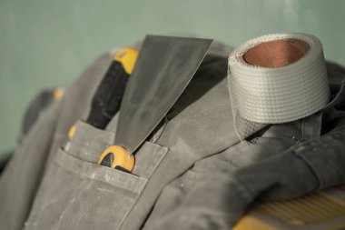 Binanın içinde evin yenilenmesi sürecinde boyacı için çalışma aracı ve özel giysi