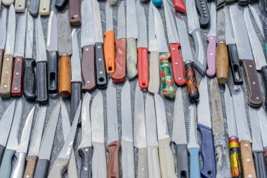 Bir desen gibi masanın üzerine yığılmış çok sayıda bıçak vardı. Bıçak şeklinde somut bir kanıt. Cinayet silahı.