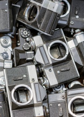 Bitpazarındaki diğer eski kamera kapaklarıyla birlikte bir yığın içinde duran eski moda bir retro kamera.