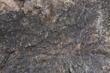 Soyut taş arka plan. Taş duvar dokusu. Yakın plan. Karanlık, harap olmuş bir uçurum. Taş ya da kaya dağlarının pürüzlü gri dokusu, jeoloji ve dağcılık teması üzerine metin için arkaplan ve kopyalama alanı.