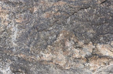 Soyut taş arka plan. Taş duvar dokusu. Yakın plan. Karanlık, harap olmuş bir uçurum. Taş ya da kaya dağlarının pürüzlü gri dokusu, jeoloji ve dağcılık teması üzerine metin için arkaplan ve kopyalama alanı.