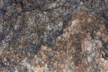 Soyut taş arka plan. Taş duvar dokusu. Yakın plan. Karanlık, harap olmuş bir uçurum. Taş ya da kaya dağlarının pürüzlü gri dokusu, jeoloji ve dağcılık teması üzerine metin için arkaplan ve kopyalama alanı.