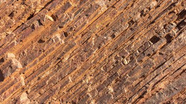 Demir ve bileşiklerini içeren doğal mineral oluşumları, bu oluşumlardan endüstriyel demir çıkarılması uygun olduğunda, böyle bir hacimde gerçekleşir. Taş ocağının taş dokusu. Ağır Sanayi için Madencilik - Demir cevheri içeren kaya dokusu ve