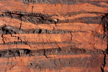 Demir ve bileşiklerini içeren doğal mineral oluşumları, bu oluşumlardan endüstriyel demir çıkarılması uygun olduğunda, böyle bir hacimde gerçekleşir. Taş ocağının taş dokusu. Ağır Sanayi için Madencilik - Demir cevheri içeren kaya dokusu ve